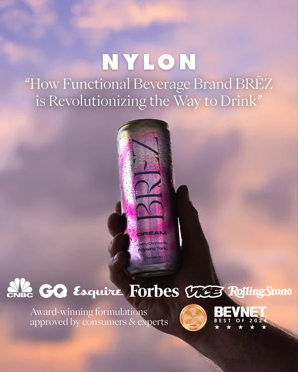 Hand holding a can of BREZ functional beverage with a purple and pink design against a blurred sky background.
